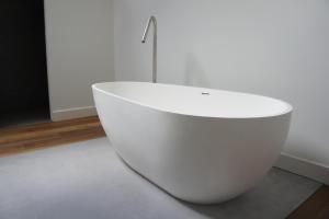莱尔瑟姆B&B en Boshuis Darthuizerpoort的一间房间里一个白色的浴缸