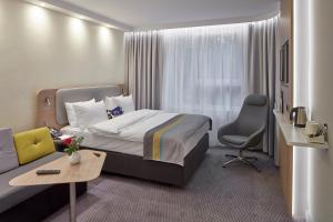 梅尔齐希Holiday Inn Express - Merzig, an IHG Hotel的酒店客房,配有床和沙发
