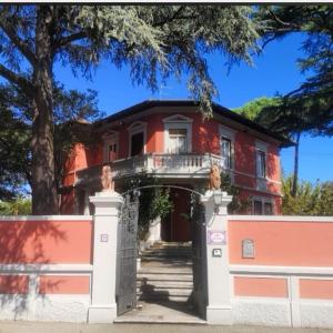 拉斯特拉阿西尼亚艾尔钢琴别墅酒店的一座红色的房子,有门和栅栏