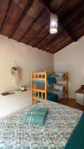 伊波兰加Canto do Sabiá PETAR Hospedagem Familiar的一间卧室设有两张床和木制天花板