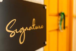 库塔伊西Boutique Apartment - Signature的门上带有 ⁇ 吓字的标志