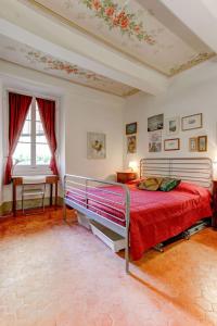芒通Les Fresques的一间卧室配有一张带红色毯子的大床