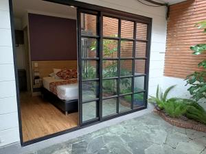 麦德林Hotel Poma Rosa的一间设有床铺和大玻璃门的房间