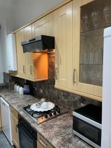奥本Heart of George street / Oban / Argyll的厨房配有木制橱柜和炉灶烤箱。
