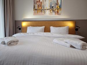 伏尔塔瓦河畔利普诺JBX Resort Avenue Lipno的卧室配有2条白色毛巾。