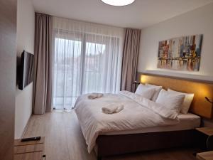 伏尔塔瓦河畔利普诺JBX Resort Avenue Lipno的一间卧室设有一张大床和一个窗户。