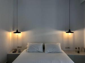 迈洛波塔斯斯里阿莫斯酒店的一间卧室配有带2个枕头和2盏灯的床