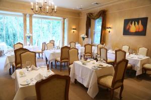 波拉尔米尔顿公园乡村度假屋酒店及Spa的用餐室配有桌椅和白色的桌布