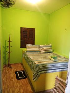 阿廷斯Casa Gael (Gisele & Lucimar)的一间卧室设有一张带绿色墙壁的床