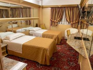 米兰Hotel Wagner的酒店客房,设有两张床和镜子