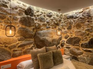 索尔波As Penedas, Casa dos Arcos的一间卧室设有石墙、一张床和灯光