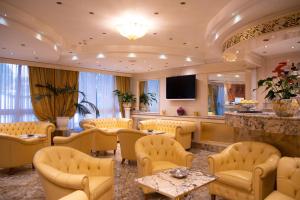 米兰Hotel Wagner的一间设有黄色桌椅和电视的等候室