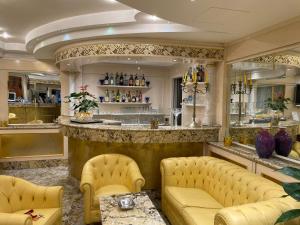米兰Hotel Wagner的一间带黄色沙发的餐厅和一间酒吧