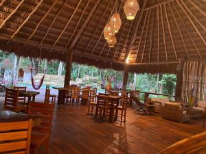巴卡拉尔Xoot Ka’Ana villa fantasía的餐厅设有木桌、椅子和吊灯。