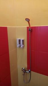 巴图Homestay Sinar Bulan的浴室里设有淋浴,铺有红色和多彩的瓷砖