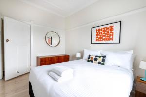 悉尼Chic Bondi Beach Pad的白色的卧室配有一张白色的大床和镜子