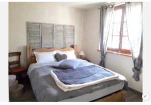圣热尔韦莱班Casa Mia的一间卧室配有一张带蓝色毯子的床和窗户。