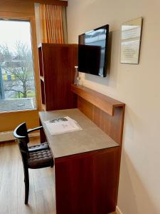 卢斯特瑙美恩德宾馆的客房设有一张桌子,墙上配有电视