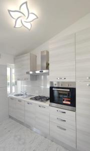 比比翁Villa Miami的厨房配有白色橱柜和炉灶烤箱。