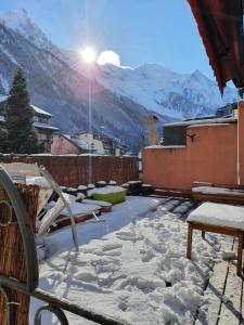 夏蒙尼-勃朗峰Chamonix Hyper centre . terrasse vue mont blanc . parking的一座白雪覆盖的庭院,在山上阳光灿烂