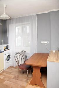第聂伯罗Apartment Pushkina的厨房配有木桌和两把椅子