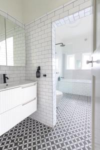 悉尼Chic Bondi Beach Pad的白色的浴室设有浴缸和卫生间。