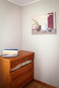 第聂伯罗Pobeda Apartment的一间设有木制梳妆台的客房,墙上挂着花瓶