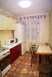 第聂伯罗Pobeda Apartment的厨房配有桌子和白色冰箱。