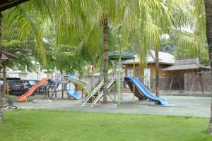 班达楠榜Kuraya Hotel Residence的一个带滑梯和棕榈树的游乐场
