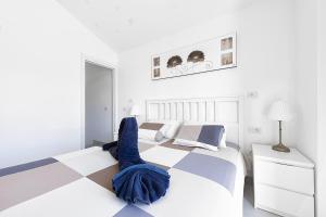 马斯帕洛马斯Villetta Green oasis club的一间白色卧室,配有一张床和一个 ⁇ 板地板