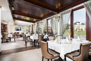 尼赖吉哈佐亚万缇诺斯酒店的餐厅设有白色的桌椅和窗户。