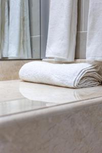 吉布提Hôtel l'Europe的浴缸边缘的白色毛巾