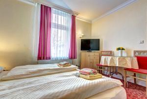 黑灵斯多夫Pension Mittag的酒店客房设有两张床和电视。