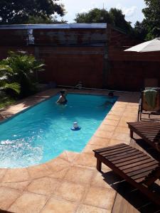 伊瓜苏港Morada Silvestre Iguazú的在游泳池游泳的人