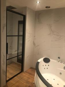 DrielB&B Driel的浴室配有白色浴缸和镜子