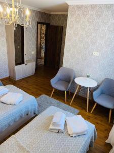 卡兹贝吉GOLDEN STAR KAZBEGI的一间设有两张床和一张桌子及椅子的房间
