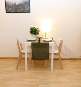美因茨Kupferberg - helles und gemütliches Appartement in Uninähe的一张带两把椅子的白色桌子和一盏灯