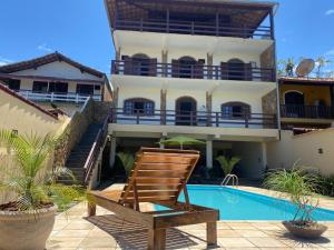 里约达欧特拉斯Praia Virgem Hostel的椅子,在带游泳池的房子前