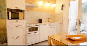 格雷乌莱班clos coutin的厨房配有白色家电和台面