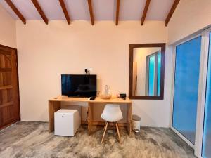 图杜Manta Stay Thoddoo, Maldives的客房设有一张带电视和镜子的书桌