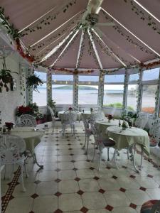 AuchencairnBalcary Bay Country House Hotel的一个带桌椅的餐厅和海滩