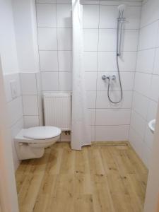 新明斯特Nordunterkunft的白色的浴室设有卫生间和淋浴。