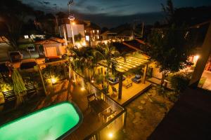 普腊亚罗萨Pousada Cacau的享有房子顶部的景色,晚上设有游泳池
