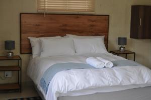 ManguziKosi Khaya的一间卧室配有一张床,上面有两条毛巾