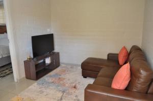 ManguziKosi Khaya的带沙发和平面电视的客厅