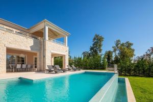 布罗托尼贾Villa Divine by ILC (Istria Luxury Collection)的一个带椅子的游泳池以及一座房子