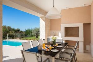 布罗托尼贾Villa Divine by ILC (Istria Luxury Collection)的一间带桌椅的用餐室和一个游泳池