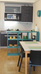 布宜诺斯艾利斯Carlos Gardel Tango Studio的厨房配有蓝色的柜台和桌子