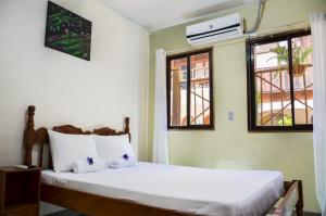 科克Cabinas Coco Alegre的一间卧室配有一张带白色床单和窗户的床。