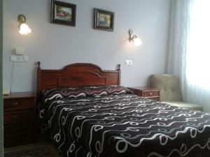 诺哈诺加利斯酒店的一间卧室配有一张带黑白毯子的床